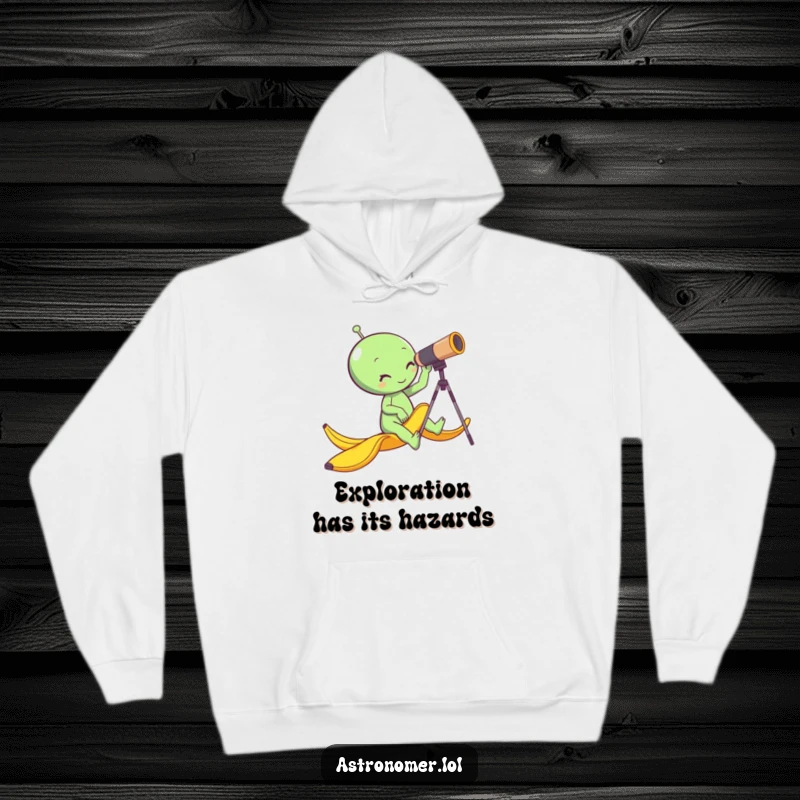 Funny alien slipping on a banana peel while looking through a telescope, warm and humorous space apparel, gag gift hoodie.