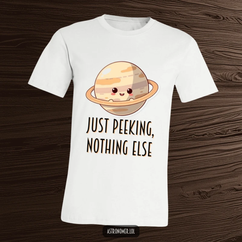 Funny T-Shirt: A smiling, curious character peeks out from behind the stunning rings of a giant planet in space.